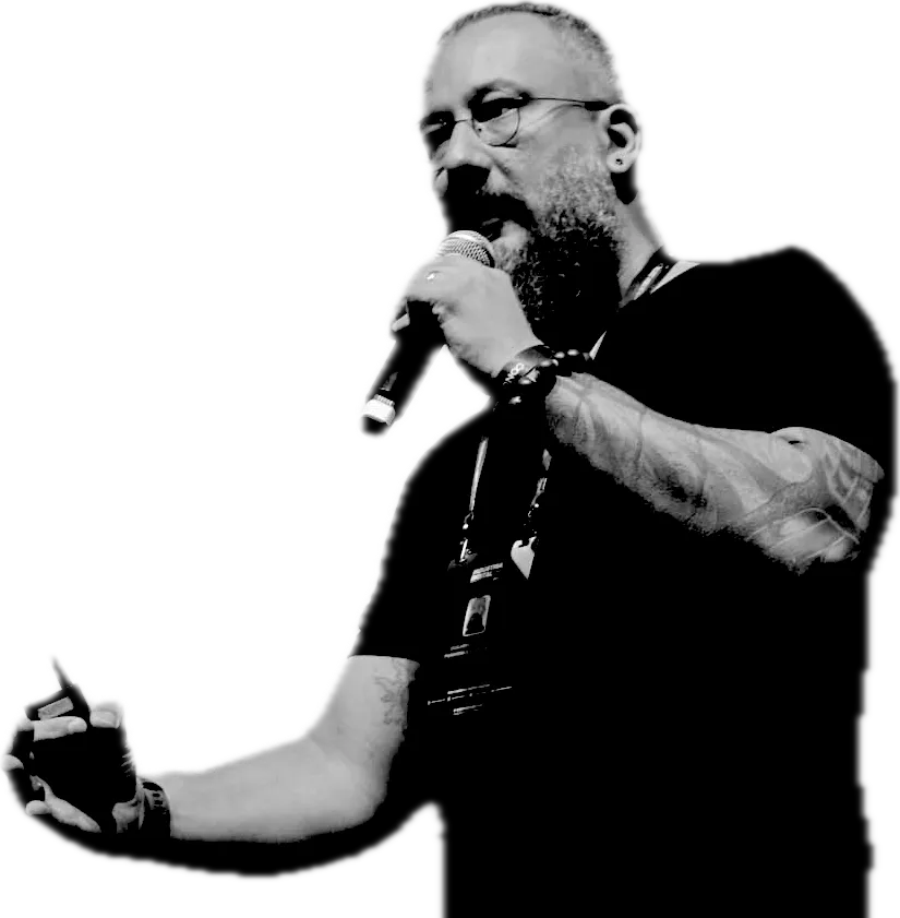 Guilherme Di Paula falando em um palco, com microfone na mão